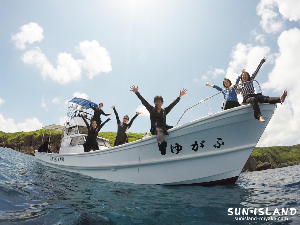 ダイビング終了後、笑顔でログ付けを楽しむ宮古島サンアイランドのお客様とスタッフ