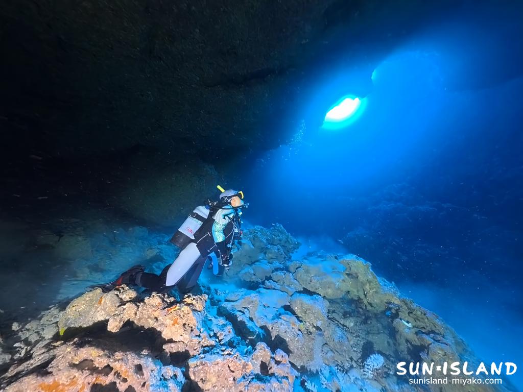 伊良部島ダイビングスポット クロスホール 洞窟内部差し込む光を見るWさん
