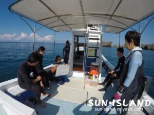 船上でダイビングポイントの説明をしている