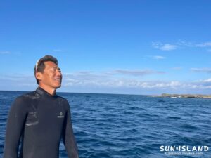 ウェットスーツを着た、竹内の自然な笑顔