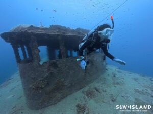 宮古島の沈船ポイントで狭い窓枠を上手に通り抜けるダイバー