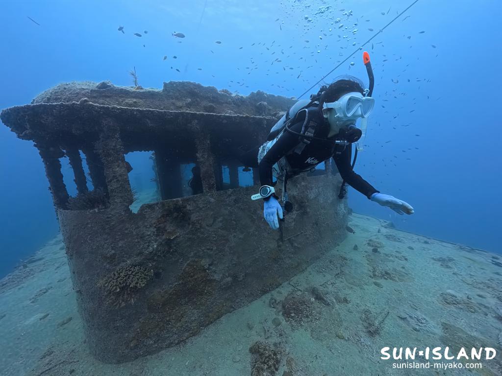 宮古島の沈船ポイントで狭い窓枠を上手に通り抜けるダイバー